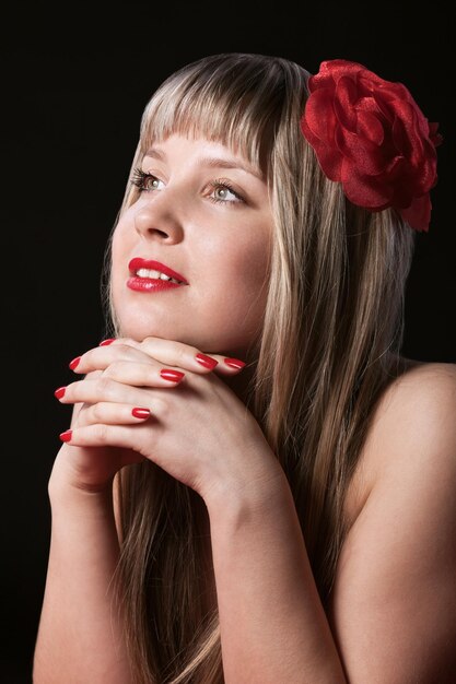 Rubio feliz con flor roja en el pelo