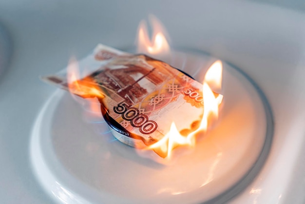 El rublo ruso está ardiendo en el concepto de fuego el aumento del precio del gas en Rusia una factura de 5000 rublos se quema en un incendio en una estufa de gas Suministro de gas caro