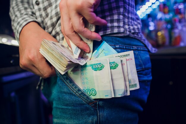 Rublos rusos, mano, jeans, escondite, robo por empleado de caja