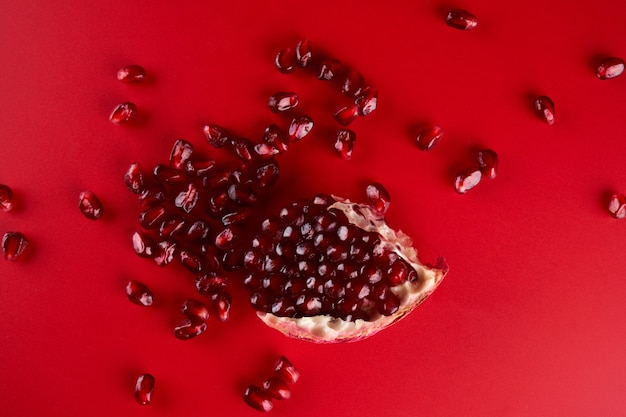 Ruby reife frische saftige Granatapfelkerne Nahaufnahme isoliert auf rotem Hintergrund