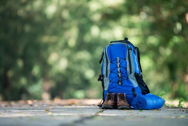 Rucksack und Schuhe Backpacker ruhen sich auf der Straße aus, während sie wandern