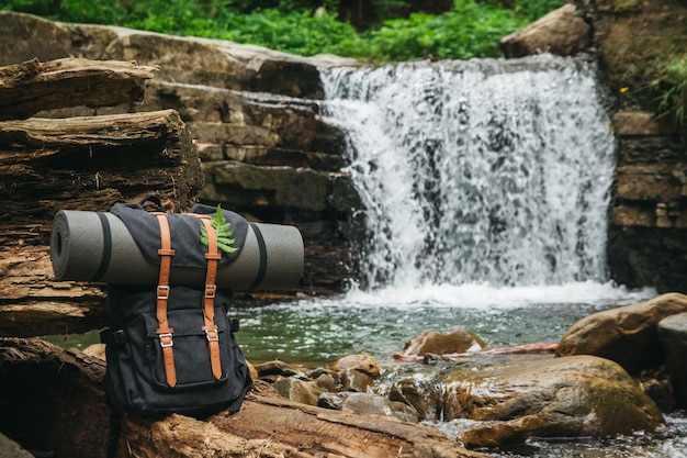 Rucksacktourismus vor dem Hintergrund des Flusses und des Wasserfalls