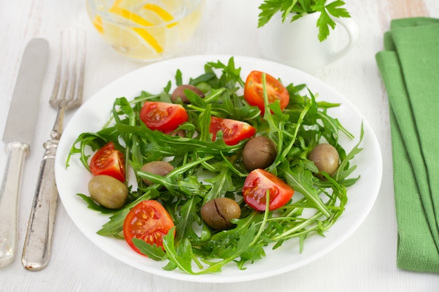 Rucola com tomate e azeitonas no prato