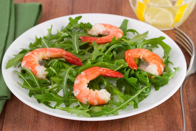 Rucola De Ensalada Con Mariscos En El Plato Y Agua De Vidrio Con Limón