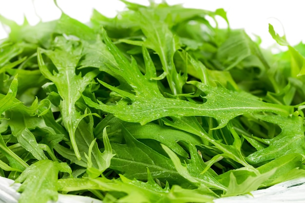 Rucola-Salat in einem Weidenkorb isoliert auf weißem Hintergrund