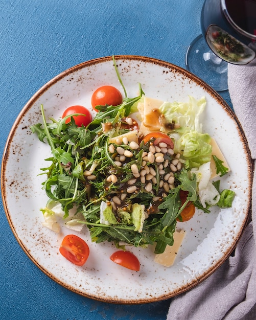 Rúcula de salada verde, tomate cereja e pinhões. Vista do topo. Fechar-se