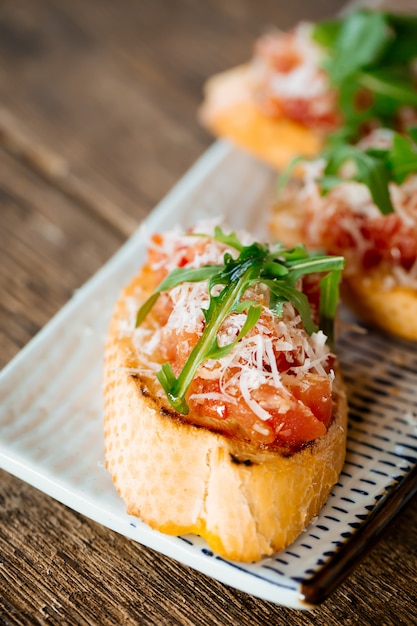 Foto rúcula italiana de tomates bruschetta y parmesano