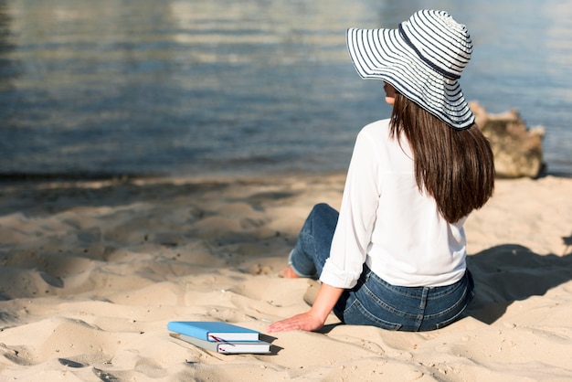 Rückansicht der Frau, die den Blick vom Strand bewundert