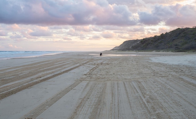 Rückansicht der Person, die ein Foto zum Sonnenuntergang in Seashore in Fraser Island, Queensland, Australien macht