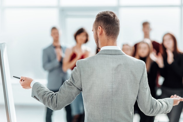 Rückansicht. Der Sprecher steht neben dem Flipchart