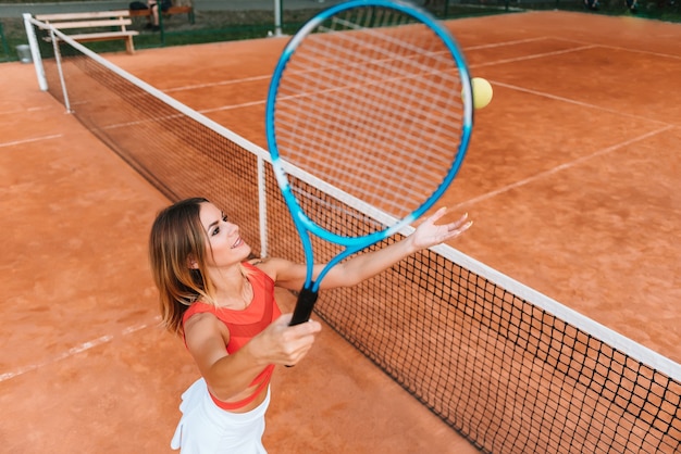 Rückansicht der Tennisspielerin in voller Länge auf dem Platz