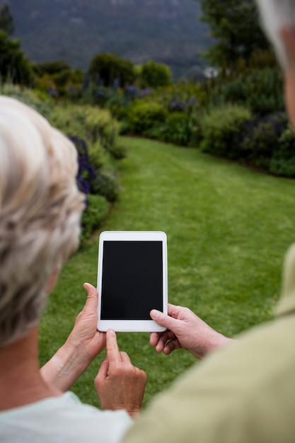 Rückansicht des älteren Paares unter Verwendung des digitalen Tablets