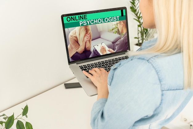 Rückansicht des Gesprächs einer Frau mit einem Psychologen oder Kollegen über eine Webcam-Konferenz auf einem Laptop, eine Frau spricht bei einem virtuellen Videoanruf mit einem Geschäftspartner oder Kunden, Online-Beratungskonzept.