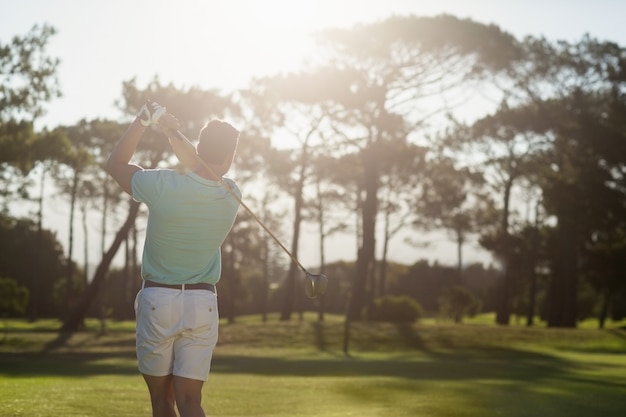 Rückansicht des jungen Golfers, der Schuss nimmt