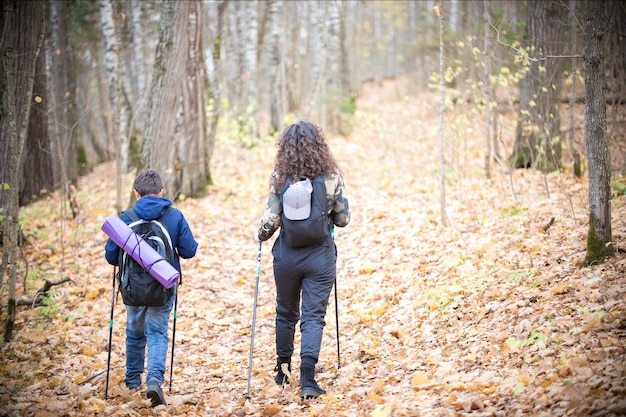 Rückansicht des kleinen Jungen und der jungen Frau des Nordic Walking