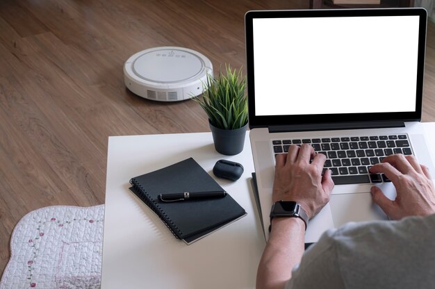 Rückansicht des Mannes, der an einem Laptop arbeitet, während er zu Hause sitzt.