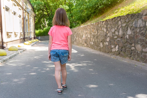 Rückansicht ein kleines kaukasisches Mädchen, das weg geht Lebensstil Das Kind auf Spaziergang