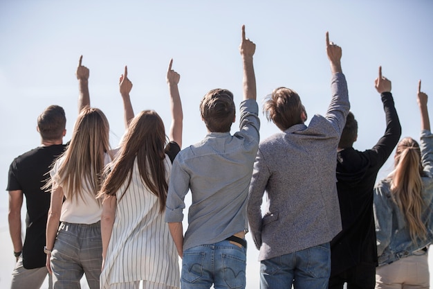 Rückansicht . eine Gruppe von Freunden, die an einem Kopienraum auftauchen. Foto mit Textraum