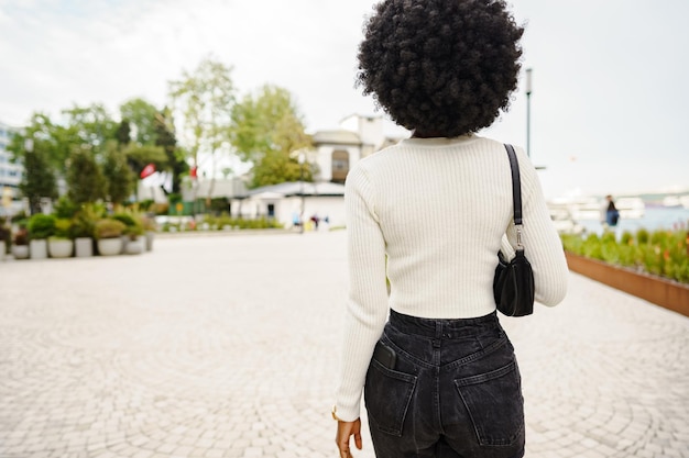 Rückansicht einer afrikanischen Frau, die in der Stadt spazieren geht