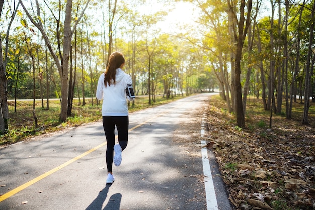 Rückansicht einer jungen asiatischen Frau, die morgens im Stadtpark joggt