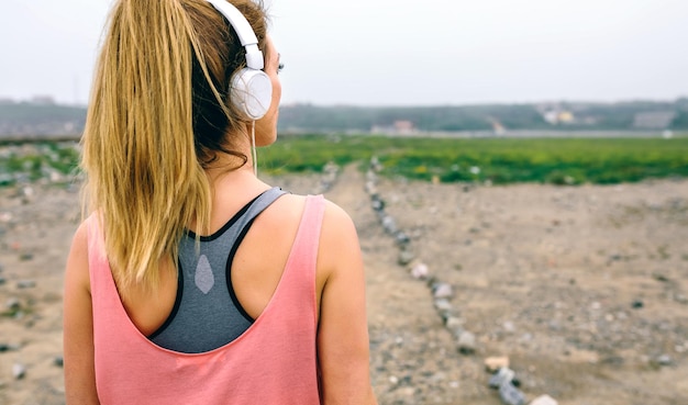 Rückansicht einer jungen Sportlerin, die den Weg beobachtet