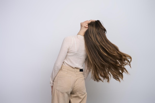 Rückansicht einer kaukasischen jungen Frau mit schönen langen Haaren isoliert auf weißem Hintergrund