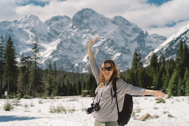 Rückansicht einer Reisenden mit Rucksack, die allein im Tal des Tatra-Gebirges in Polen unterwegs ist