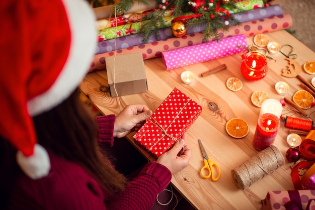 Rückansicht eines Mädchens mit dunklem Haar im Weihnachtshut, Geschenkverpackungen