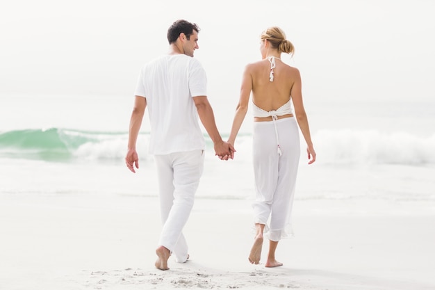 Rückansicht eines Paares zu Fuß am Strand