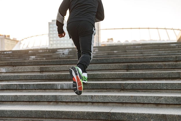 Rückansicht eines Sportlers, der die Treppe hinaufläuft