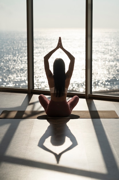 Foto rückansicht frau macht yoga-pose