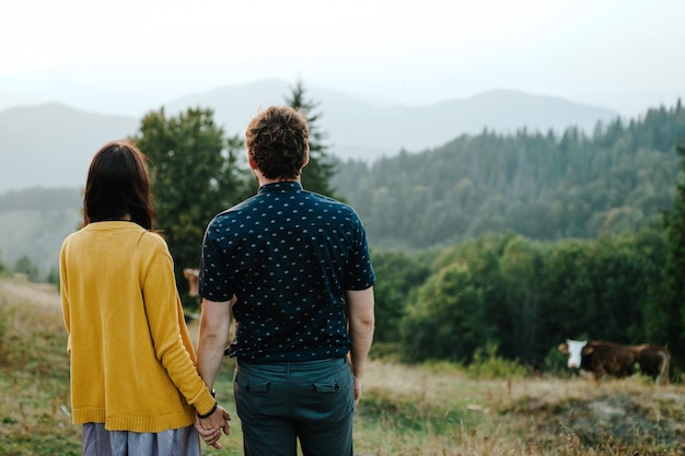 Rückansicht Paarreisende Mann und Frau, die auf Berge und Wolken blicken Liebe und reise glückliche Emotionen Lifestyle-Konzept