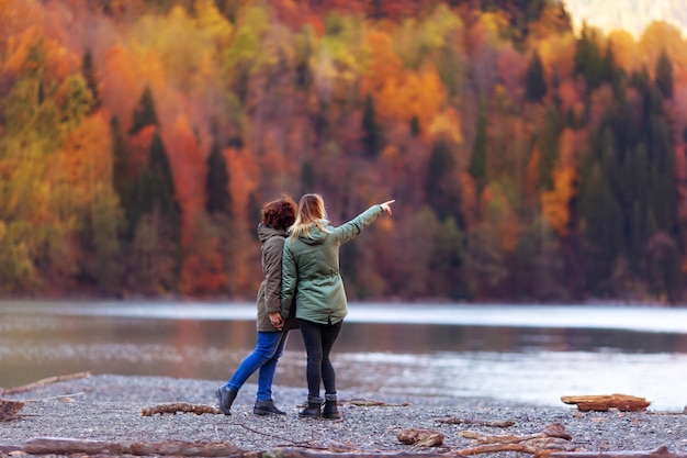 Rückansicht von Mädchen, die Herbstberge und See betrachten