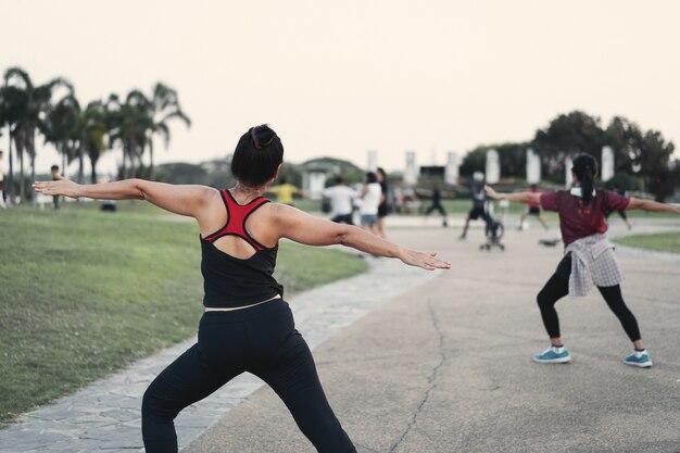 Rückansicht von reifen, gesunden Menschen, die abends nach der Arbeit im Stadtpark Aerobic tanzen, um sich zu entspannen und ein gesundes Leben zu führen. Sport und Erholung