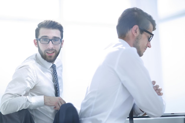 RückansichtGeschäftskollegen sitzen werktags am Deskoffice