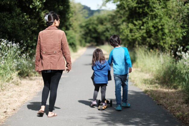 Rückblick auf die gesamte Länge der Mutter, die mit den Kindern auf der Straße geht