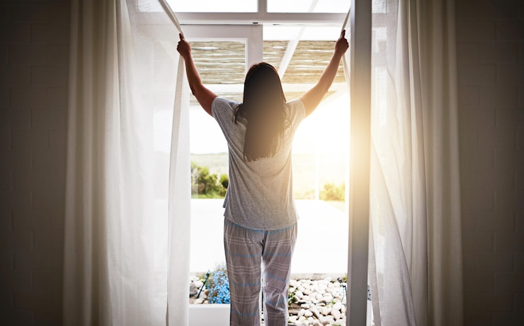 Foto rücken frau und offene glastür im morgenfenster und frisch aufwachen mit sonnenaufgang im hotel bereit für den tag routine außenblick und urlaub oder wochenende vorhang und licht in der wohnung mit terrasse