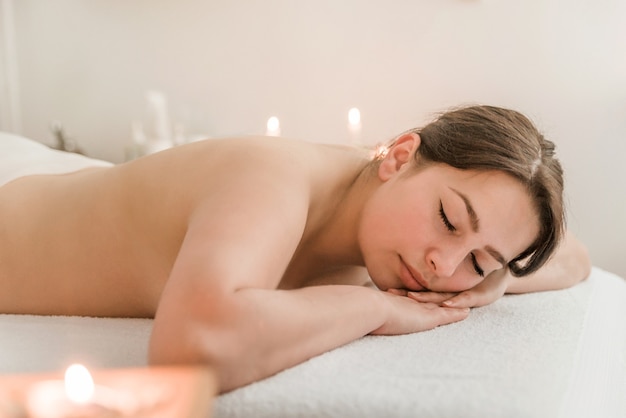 Rückenmassage für eine junge Frau im Spa, nützliche Behandlungen zum Entspannen bei Kerzenlicht und Aromatherapie