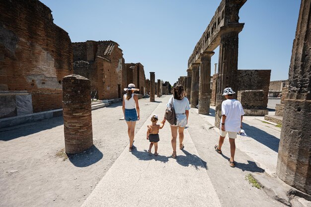 Rückseite des Familientouristen zu Fuß in der antiken Stadt Pompeji Italien