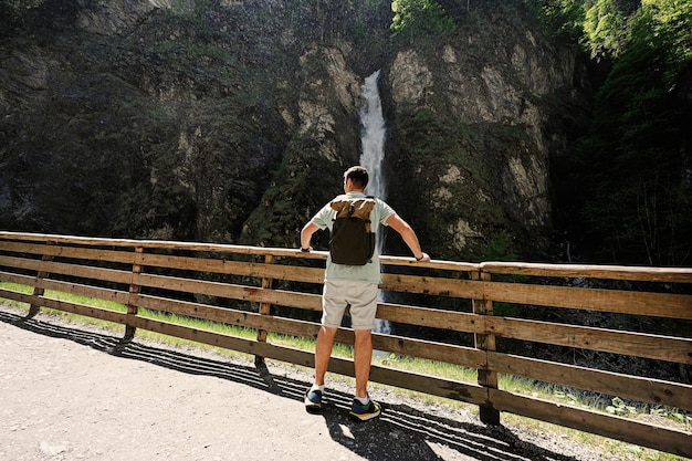 Rückseite des Mannes mit Rucksack gegen Wasserfall in Liechtensteinklamm oder Liechtensteinklamm Österreich