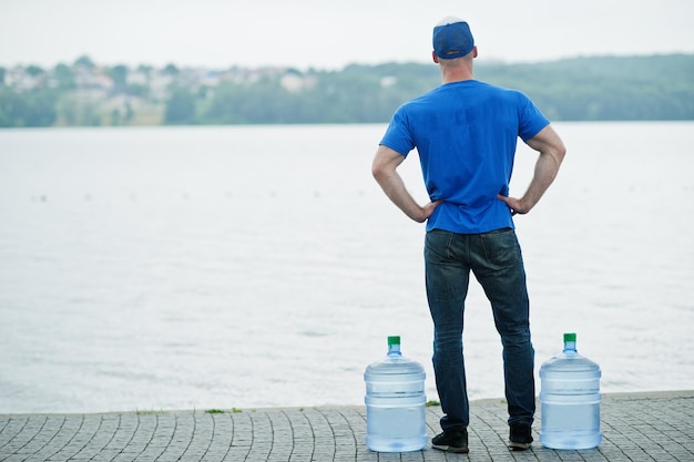 Rückseite des Zustellers mit Wasserflaschen an den Händen