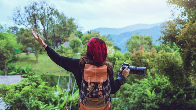 Rückseite einer Frau mit Rucksack, die im Wald steht