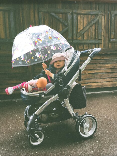 Foto rücksicht auf eine frau mit einem regenschirm auf der straße