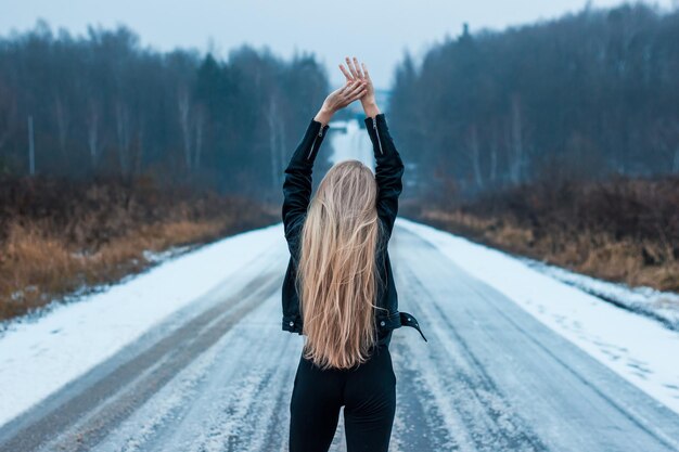 Foto rückwand einer frau, die auf einer schneebedeckten straße steht