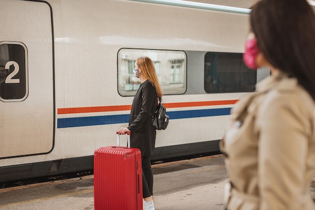 Foto rückwand einer frau im zug am bahnhof