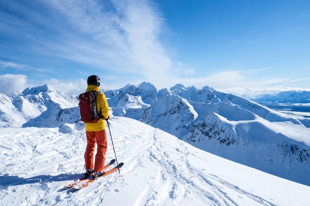 Rückwand einer Person, die auf einem schneebedeckten Berg gegen den Himmel Ski fährt