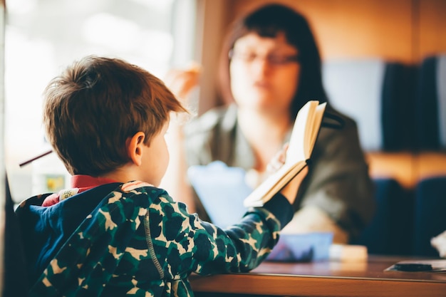 Rückwand eines Jungen, der im Zug ein Buch liest