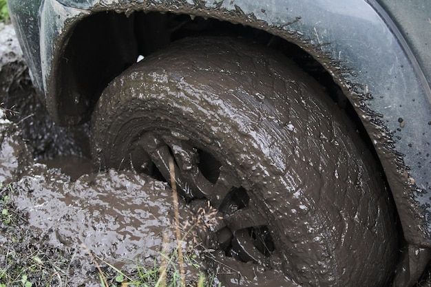 Rueda de cerca en un paisaje rural con una carretera embarrada