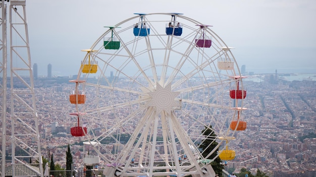 Rueda de la fortuna en el fondo del cielo nublado cabañas de arco iris visión general nublada en la ciudad de barcelona