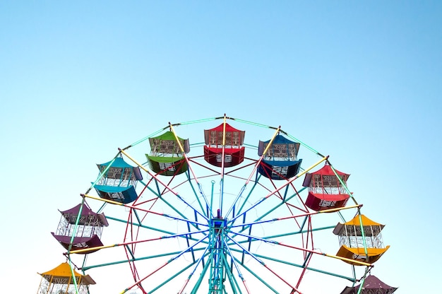 Rueda de la fortuna Jugador de los niños divertidos con cielo azul Rueda de la fortuna antigua y vintage